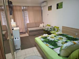 a bedroom with a bed and a living room at Nela Apartmani in Niš