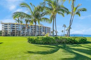 a hotel on the beach with palm trees at Kihei Surfside 306 · KSS 306 Updated BeachFront 1BD w Ocean View in Wailea