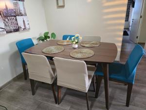 einen Esstisch mit blauen Stühlen und einem Holztisch in der Unterkunft Fabuloso Amplio Departamento 3 dorm Parcking y Wifi in Rancagua