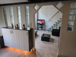 a living room with a large white cabinet and a tv at Urban Oasis - BIG stylish Apartment in Schiedam +8 photos