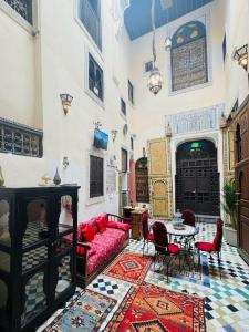 a living room with a red couch and a table at Riad Panoramik in Fès