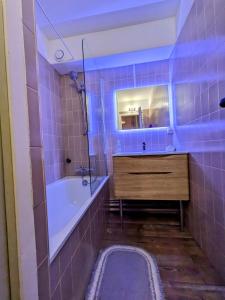 ein Badezimmer mit Badewanne, Waschbecken und Spiegel in der Unterkunft Superbe appartement au pied des pistes -Le chamois in Les Déserts