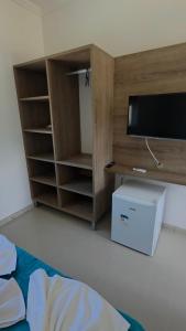 une pièce avec une télévision et un meuble contenant une boîte dans l'établissement Vila das Marés Beach Hotel, à São Sebastião