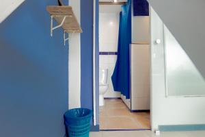 une salle de bain avec toilettes et un mur bleu dans l'établissement Casa Caracol, à Cadix 62 autres photos
