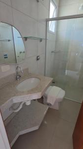 une salle de bain avec un lavabo, des toilettes et un miroir dans l'établissement Vila das Marés Beach Hotel, à São Sebastião
