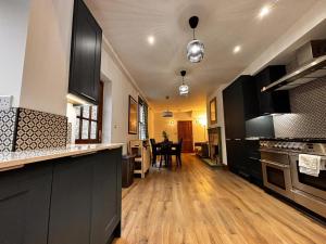 a kitchen with black cabinets and a wooden floor at "Ivyholme" Superb Premium House in Central Durham Location in Durham