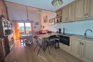 eine Küche mit Tisch und Stühlen in einem Zimmer in der Unterkunft Appartement familial au Revard vue sur le jardin d'enfant et pistes in Les Déserts