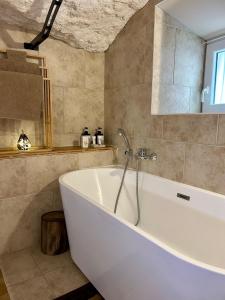 Una bañera blanca en un baño. en Le Cocon Secret, en Saint-Cyr