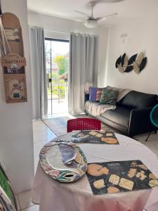 a living room with a table and a couch at Residencial COLIBRI in Garopaba