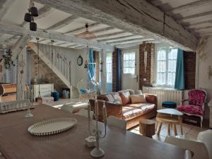 ein Wohnzimmer mit Sofa und Tisch in der Unterkunft Maison féérique et ludique, avec jeux de piste in Saint-Romain-le-Preux + 53 Fotos