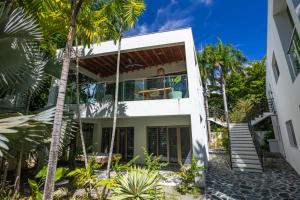 a house with palm trees in front of it at ProCab Kaya Apartments Cabarete in Cabarete