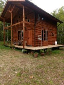 une cabane en rondins avec terrasse couverte dans une cour dans l'établissement Cabaña entre Arboles, à Villarrica