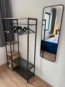 un miroir sur un mur à côté d'une chambre dans l'établissement Modernes Apartment mit Parkplatz und 24h Check-in, à Niederdorla