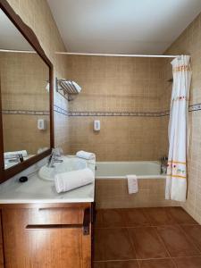 a bathroom with a sink and a tub and a mirror at Posada de Jose Mª El Tempranillo in Alameda