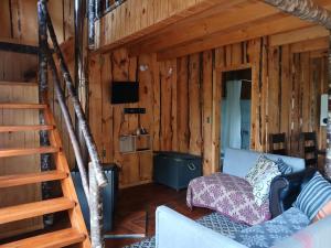 - un salon avec un escalier dans une cabane en rondins dans l'établissement Cabaña entre Arboles, à Villarrica
