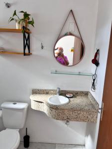ein Badezimmer mit Waschbecken, Spiegel und Toilette in der Unterkunft Residencial COLIBRI in Garopaba