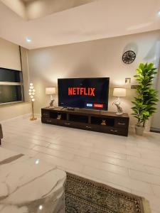 a living room with a television on a wall at One Bedroom apartment Centaurus Islamabad in Islamabad