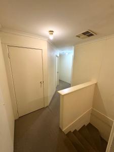 een lege kamer met een deur en een hal bij Affordable accommodation in Perth