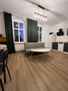 un salon avec un canapé et une table dans l'établissement Apartamenty Cytryn, à Gliwice
