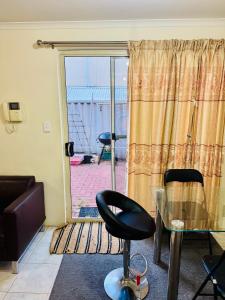 een woonkamer met een glazen tafel en een stoel bij Affordable accommodation in Perth