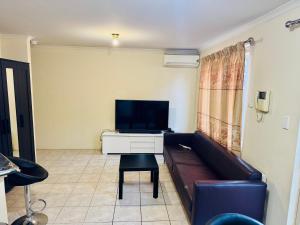 a living room with a couch and a tv at Affordable accommodation in Perth