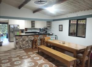 Una cocina con una mesa de madera y un comedor. en El Roble, en San Carlos