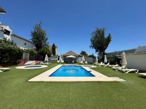a swimming pool in a yard with lawn chairs and umbrellas at Posada de Jose Mª El Tempranillo in Alameda