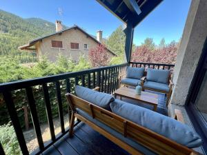 d'un balcon avec deux chaises et un banc sur une terrasse. dans l'établissement Triplex 8 people 4 bedrooms, à Saint-Chaffrey