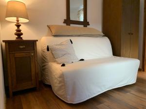 a large white bed sitting next to a lamp at Dévér Apartman in Gárdony