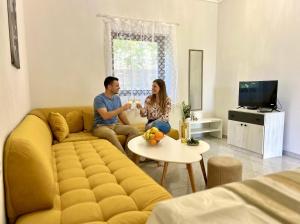 a man and woman sitting on a couch in a living room at Guest House Julia in Stavros