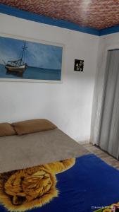 a bedroom with a bed with a painting on the wall at Vila Sol & Mar Gaibu PE in Cabo de Santo Agostinho