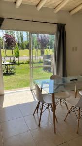 een eetkamer met een glazen tafel en stoelen bij Cabañas Vista andes in Ciudad Lujan de Cuyo +3 foto's