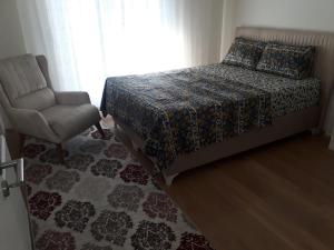 a bedroom with a bed and a chair and a window at ziraat in Soma