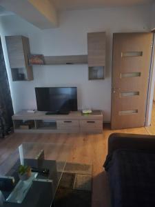 a living room with a flat screen tv and a couch at Apartament central in Craiova
