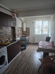 a kitchen with a stove and a table in a room at Apartament central in Craiova