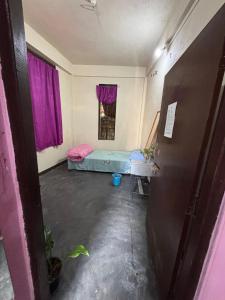 KohīmaHornbill Guest House的一间有床和紫色窗帘的房间