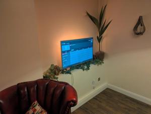 een woonkamer met een bank en een televisie aan de muur bij Benny's Hideout - City Centre - Parking - 2BR in Belfast +7 foto's