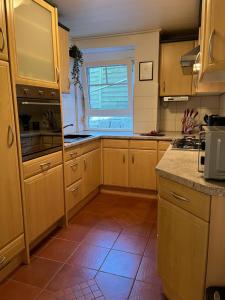 una cucina con armadi in legno e pavimento piastrellato di Rottal-AlpakaLodge Zeit zu Zweit im Grünen a Abtsgmünd