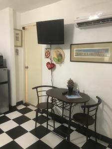 mesa de comedor con sillas y TV en la pared en 310Guest-House La Vida, en San Juan