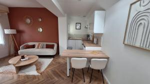 una sala de estar con una mesa y un sofá en La Maison Des Pins, en Le Mans