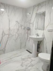 a white bathroom with a sink and a toilet at JackRouivo in Marrakech