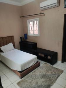 a bedroom with a bed and a desk and a window at JackRouivo in Marrakech