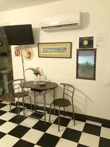 Un comedor con una mesa y sillas sobre un suelo a cuadros. en 310Guest-House La Vida, en San Juan