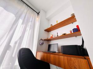 a room with a desk with a television and a window at Harlem Suites in Kiambu