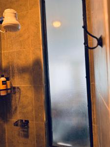 a shower with a glass door next to a window at Harlem Suites in Kiambu +10 photos