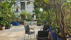 a patio with chairs and trees and a table at Sky Garden Home in Dhaka