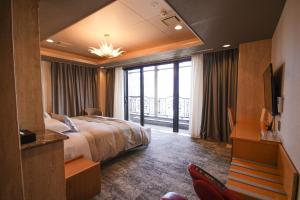 ein Hotelzimmer mit Bett und Balkon in der Unterkunft ザレジデンスホテル岡山 in Okayama