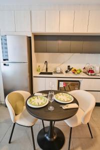 基多Studio Harmony in La Carolina and Wet Areas的厨房配有桌子、两把椅子和冰箱