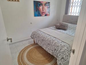 Un dormitorio con una cama y un cuadro en la pared. en Het Verwende Nest, en La Mata