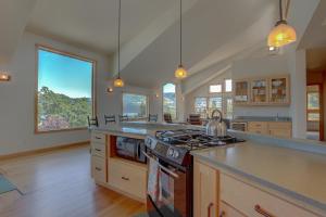 a large kitchen with a stove and some windows at Hutson's Bridgeview 30 Day in Hood River